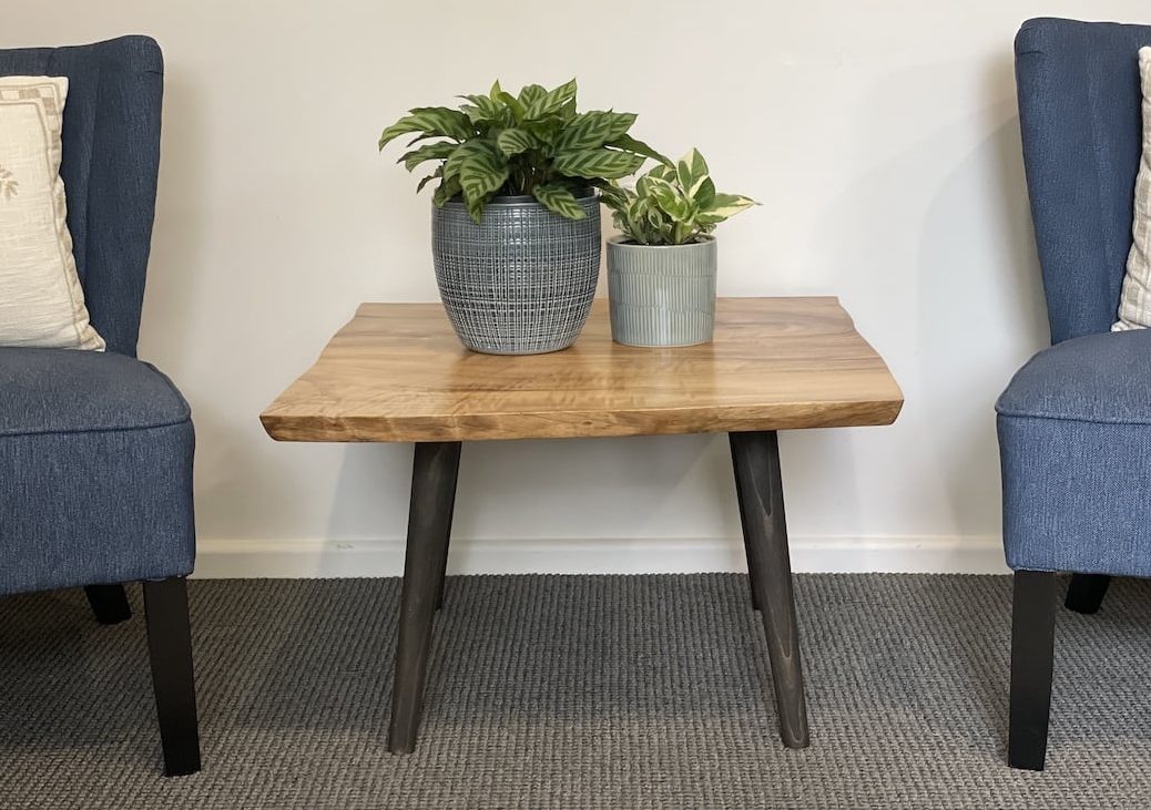 small-custom-made-coffee-table-view-5 Front view of a Camphor Laurel coffee table with four black tapered black timber legs